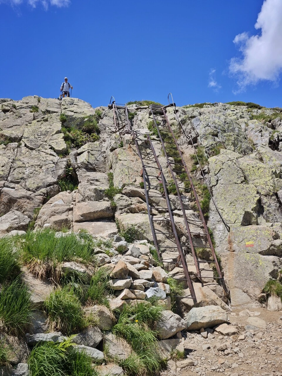 A hiker at the top of the metal ladders at Trè-le-Champ